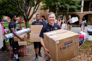 Wake Forest hosts move-in day for first year students at the south campus residence halls on Friday, August 21, 2015.  Head football coach Dave Clawson and several of his players carry items into Bostwick.